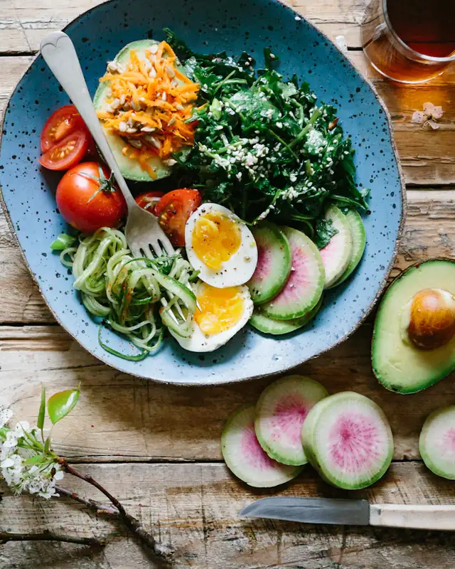 Bowls of vegetables, grains and fruit seen from above